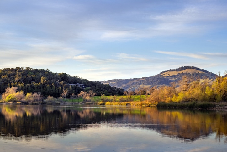 Spring Lake Regional Park, a public park in Santa Rosa, California, in Sonoma County wine country. Beautiful rolling hills and autumn foliage in the afternoon reflected in the lake.